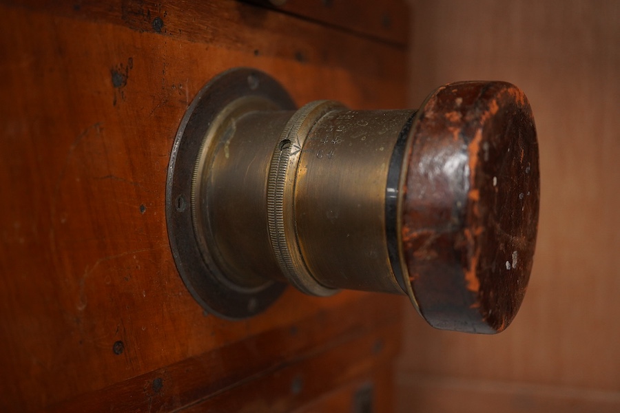 An early 20th century brass mounted mahogany full plate camera, together with a glass negative holder. Condition - fair to good.